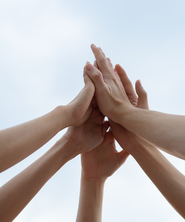 手を重ねる人々の写真